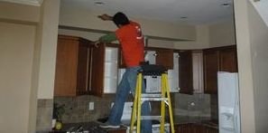 Water Damage Tech Conducting A Ceiling Repair Job